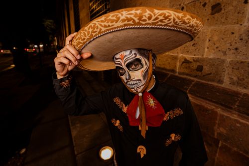 Free A man with face paint in a sombrero poses in a traditional Mexican outfit, capturing cultural essence. Stock Photo