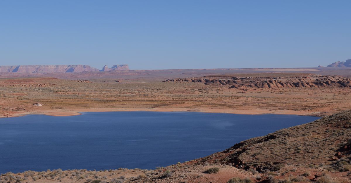 Stunning view of a lake surrounded by arid desert terrain, perfect for travel and adventure enthusiasts.