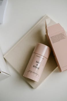 Stylish pink deodorant bottle with box on a white background, ideal for beauty product promotions.