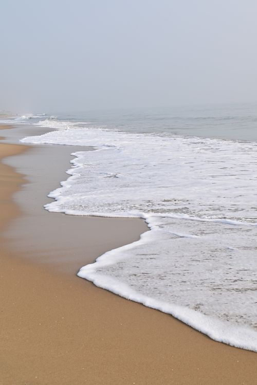 Free Calm waves wash the sandy shores of Chennai beach, capturing serene coastal beauty. Stock Photo