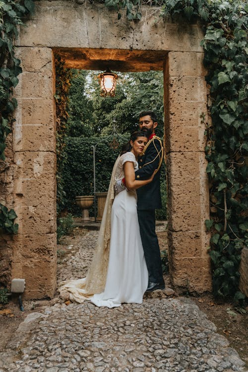 Bride and Groom Standing in a Garden and Hugging 