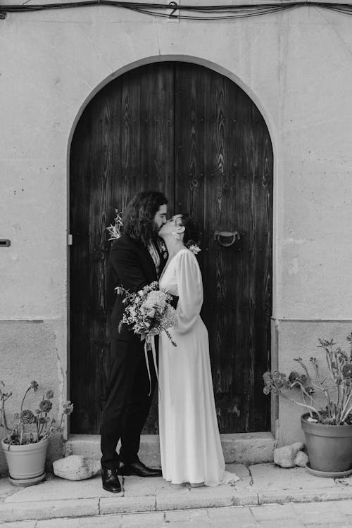 Bride and Groom Kissing in front of Old Wooden Door