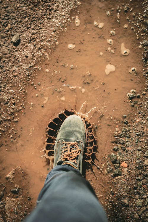 Man Wearing Gray Shoe Standing on Brown Soil