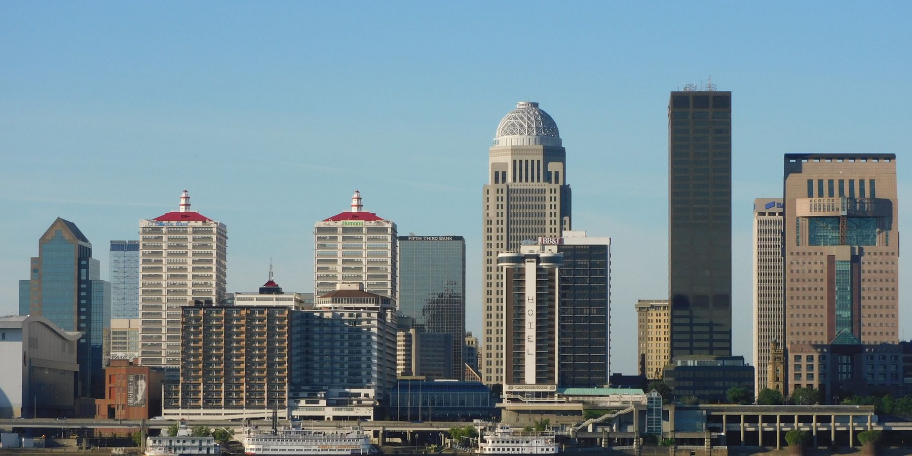 Stunning view of Louisville's skyline with modern skyscrapers reflecting on river.