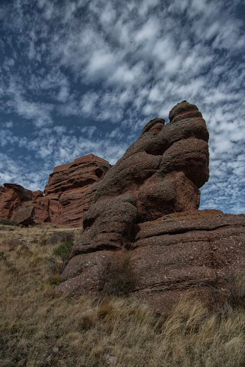 Free Vertical shot of eroded rock formations in a rural landscape with dramatic sky. Stock Photo