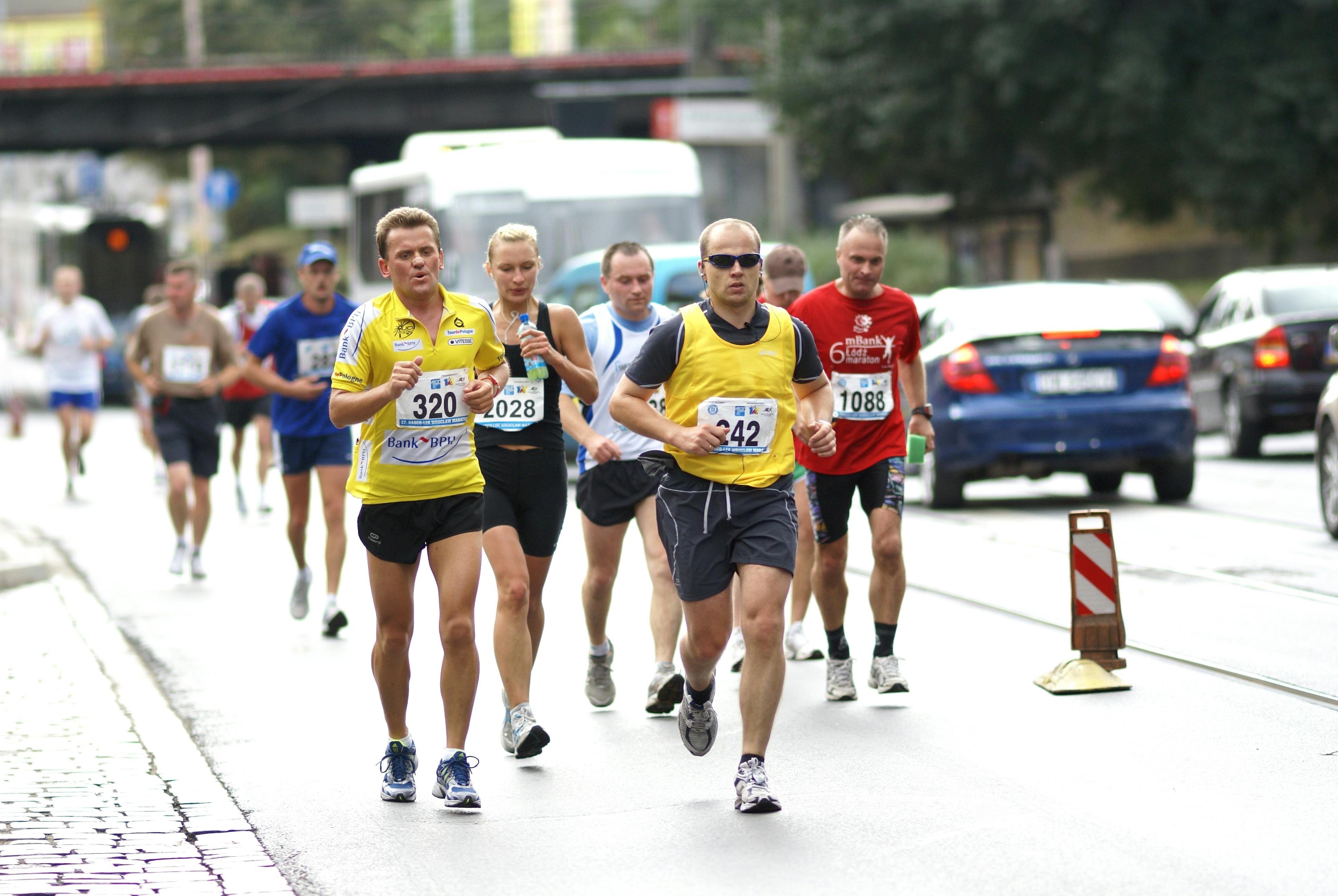 Corredores con dorsales compitiendo en una marat&oacute;n urbana