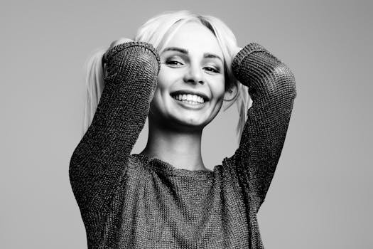 这幅黑白肖像画描绘了一位双手插在头发上、快乐微笑的女人