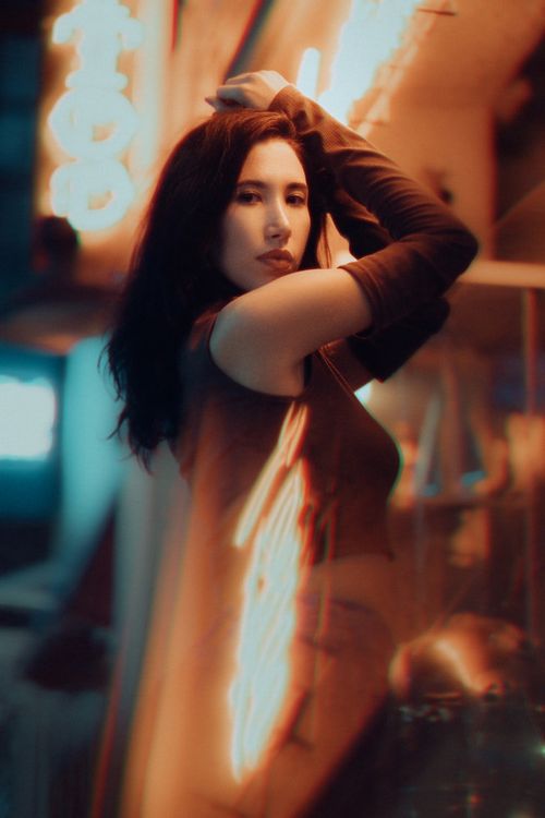 Free Elegant woman posing against vibrant city lights in Fethiye, perfect for fashion and urban themes. Stock Photo