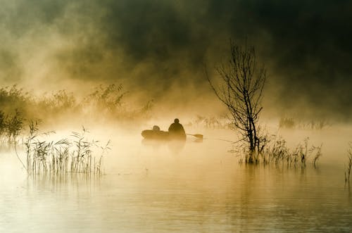 Person on Boat Among Fog over Lake