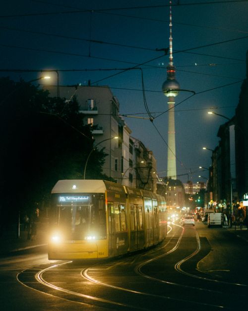 Free Illuminated Berlin street with tram and Fernsehturm at night. Stock Photo