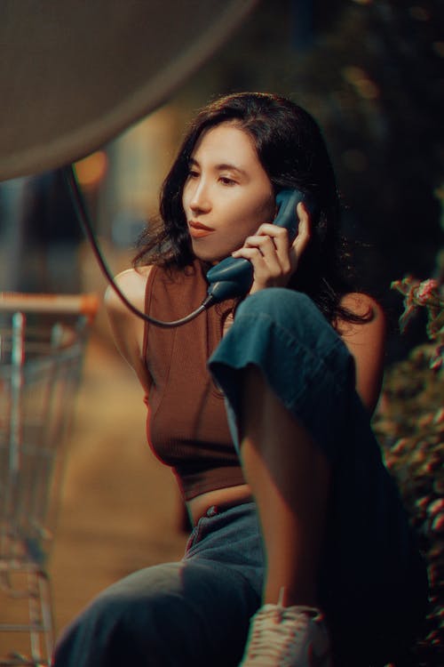 Woman Sitting with Telephone Handset