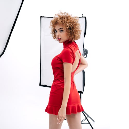 Young Woman in a Red Dress Posing in a Studio 