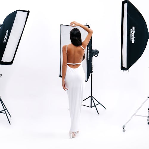 Back View of a Woman in a White Dress Posing in a Studio 