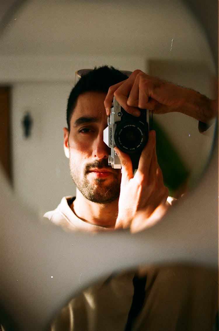 Man Taking A Mirror Selfie With A Film Camera 