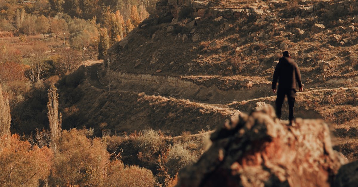 A man standing on top of a rock overlooking a valley