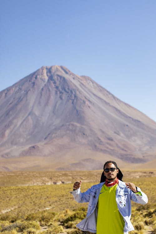 Man in Sports Jacket Posing at Foot of Mountain
