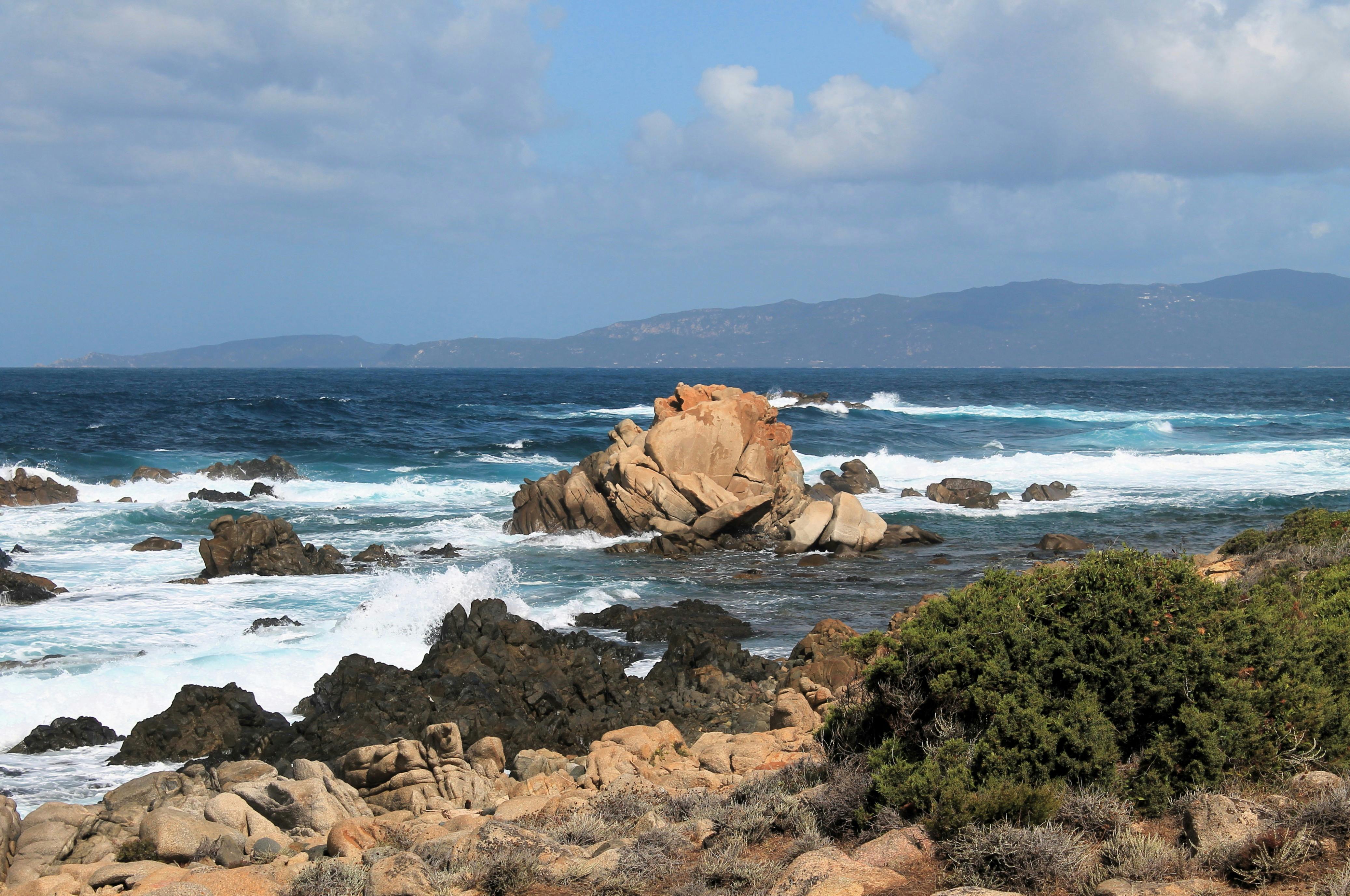 Rocks Protruding from Shallow Water by Sea Shore · Free Stock Photo