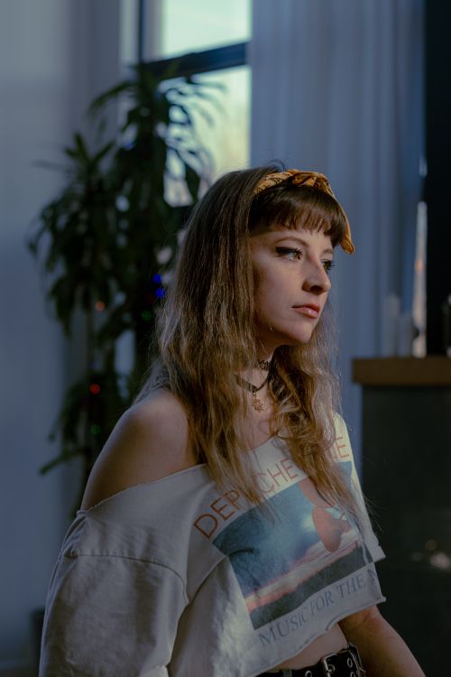 Free Fashionable woman with a headband posing indoors with soft lighting. Stock Photo