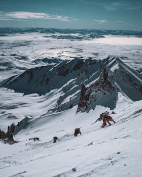 Group of climbers ascending a snowy mountain in winter, showcasing adventure and breathtaking scenery.