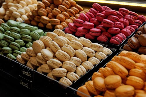 Piles of Colorful Macaroons in Crates Displayed on a Shop Shelf