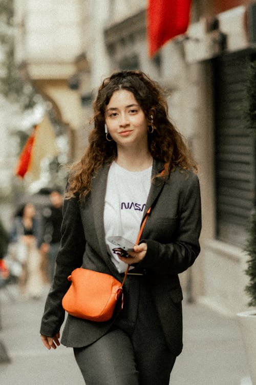 Woman Wearing Blazer and Orange Bag Walking down Street