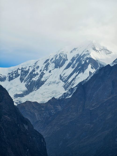 Free Breathtaking view of a snowcapped mountain range under a cloudy sky, capturing nature's grandeur. Stock Photo