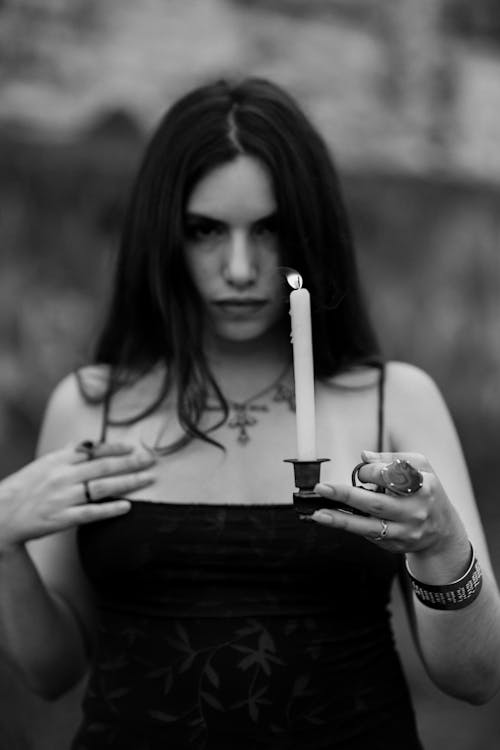 Black and White Photo of Woman Holding Lit Candle
