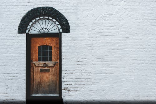 View of Old Wooden Door in a White Brick Wall 