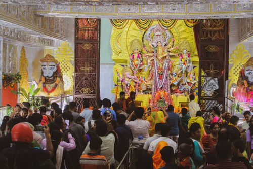 Free Crowd gathered for a vibrant Durga Puja celebration inside a decorated temple. Stock Photo