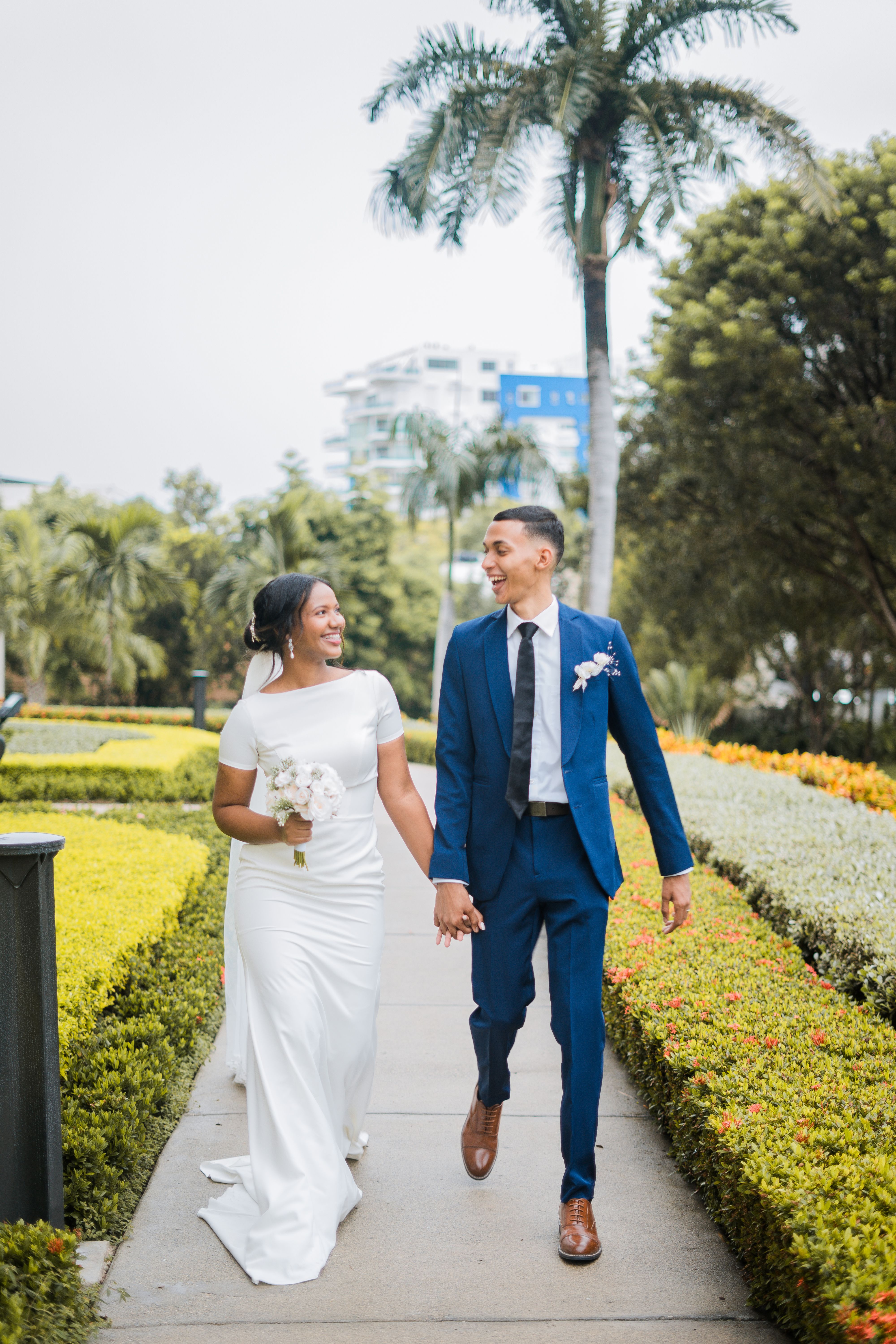 Bride and Groom Holding Hands and Smiling while Walking in a Park ...