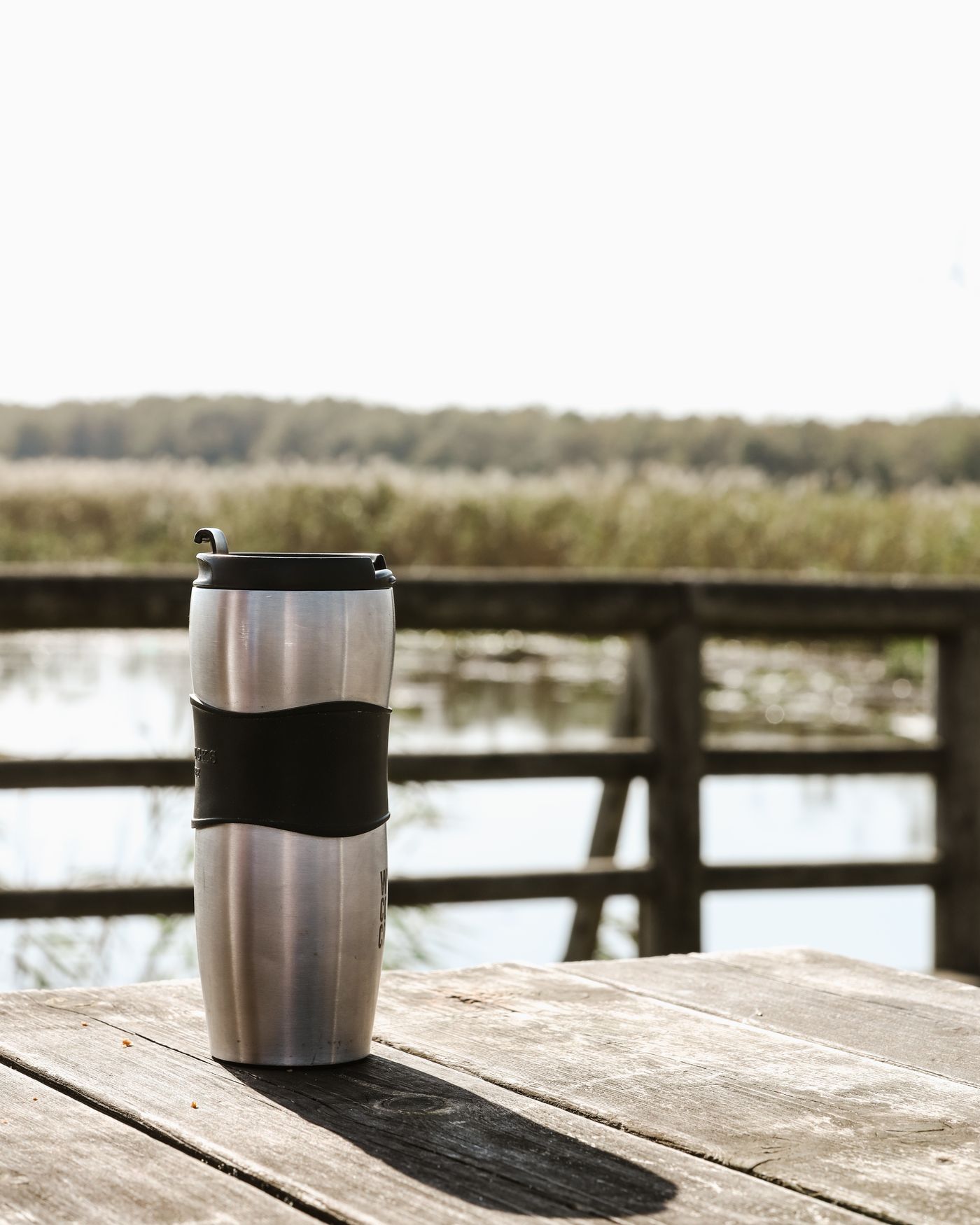 Stainless steel travel mug on an outdoor table