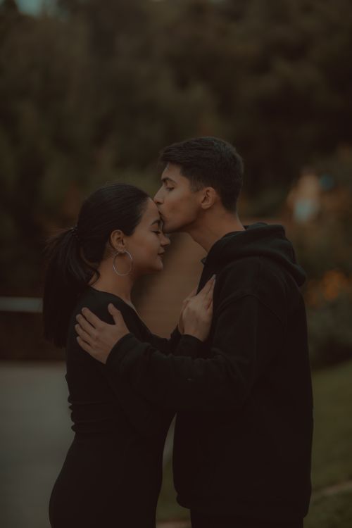 Free A romantic moment captured between a couple sharing a kiss in a Bakü park setting. Stock Photo