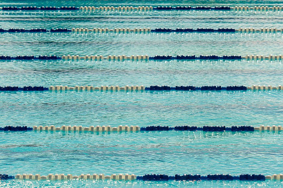 A tranquil view of an empty Olympic swimming pool with lane dividers.