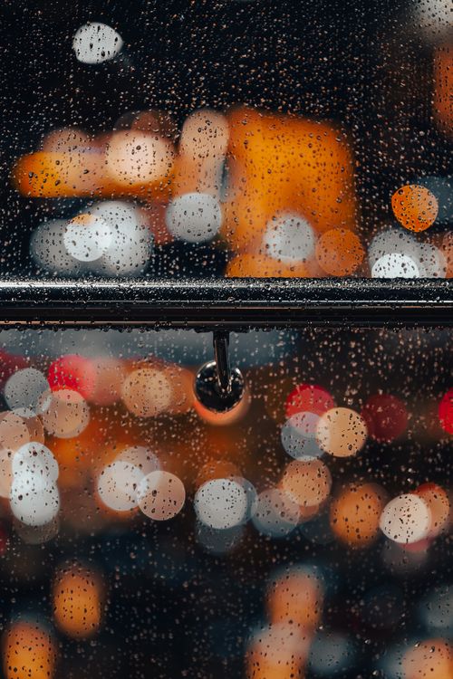 Free A rainy night in Ankara, showcasing blurred city lights through a wet window. Stock Photo