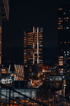 Vibrant cityscape of Ankara, Türkiye at night featuring modern skyscrapers and urban lights.
