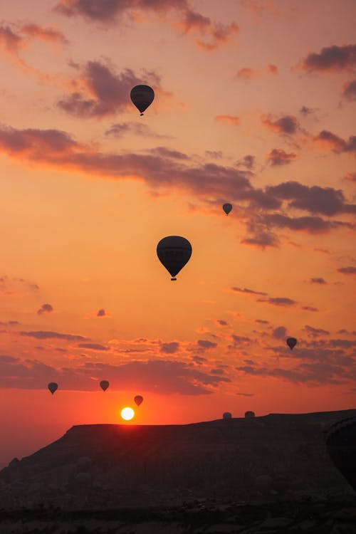 Silhouette of Balloons Flying in the Sky at Sunset 