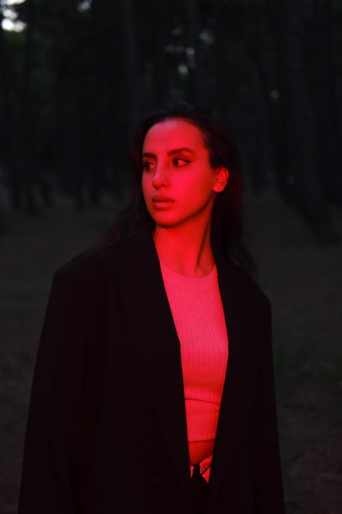 A woman in a black jacket and red light