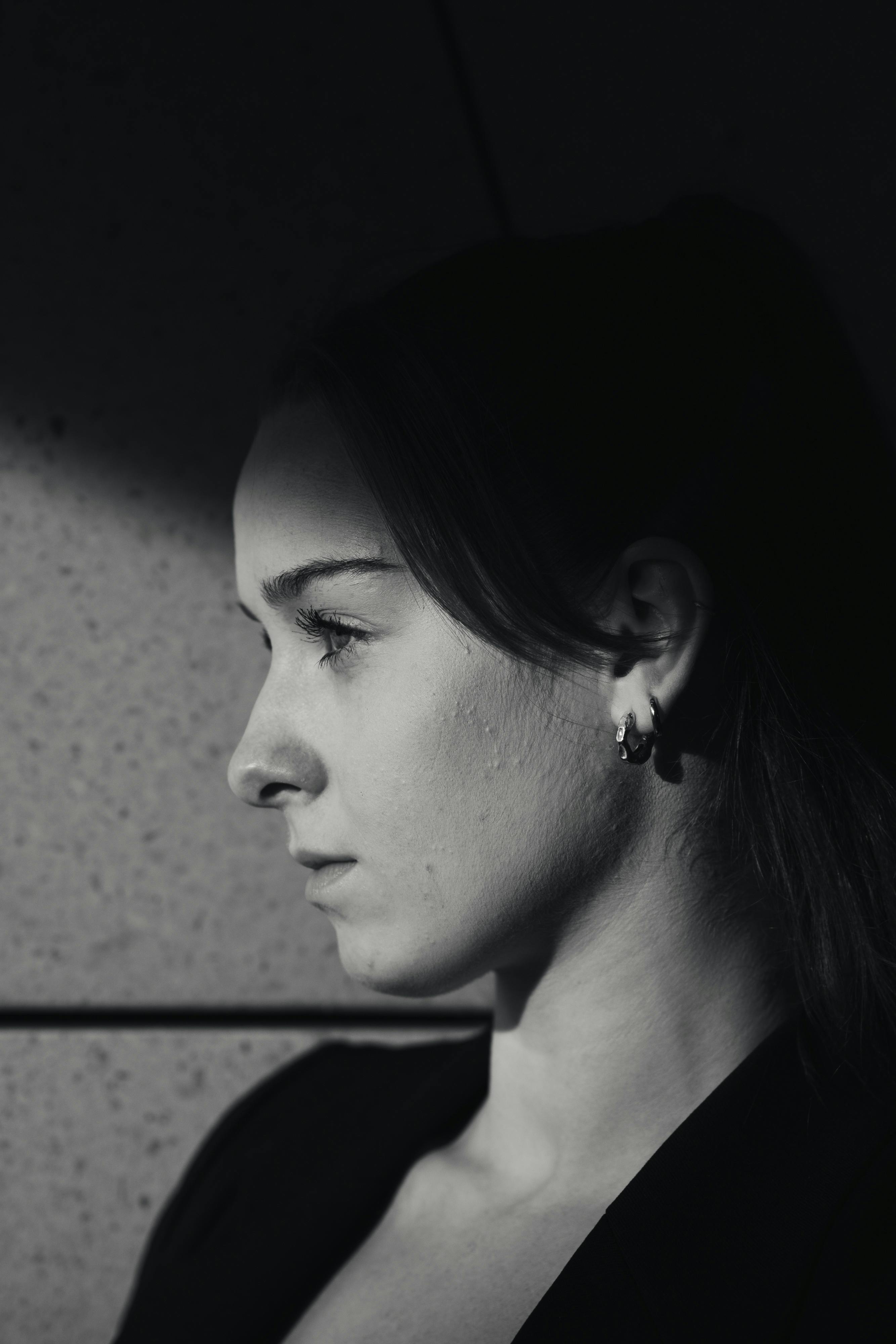Stunning black and white portrait of a woman against a wall in Berlin.