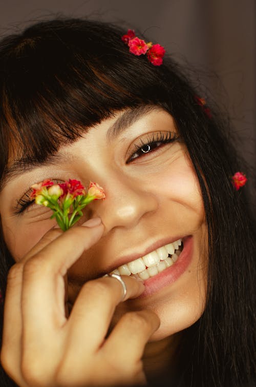 Close-up Shot of a Young Woman Holding Flowers and Smiling 