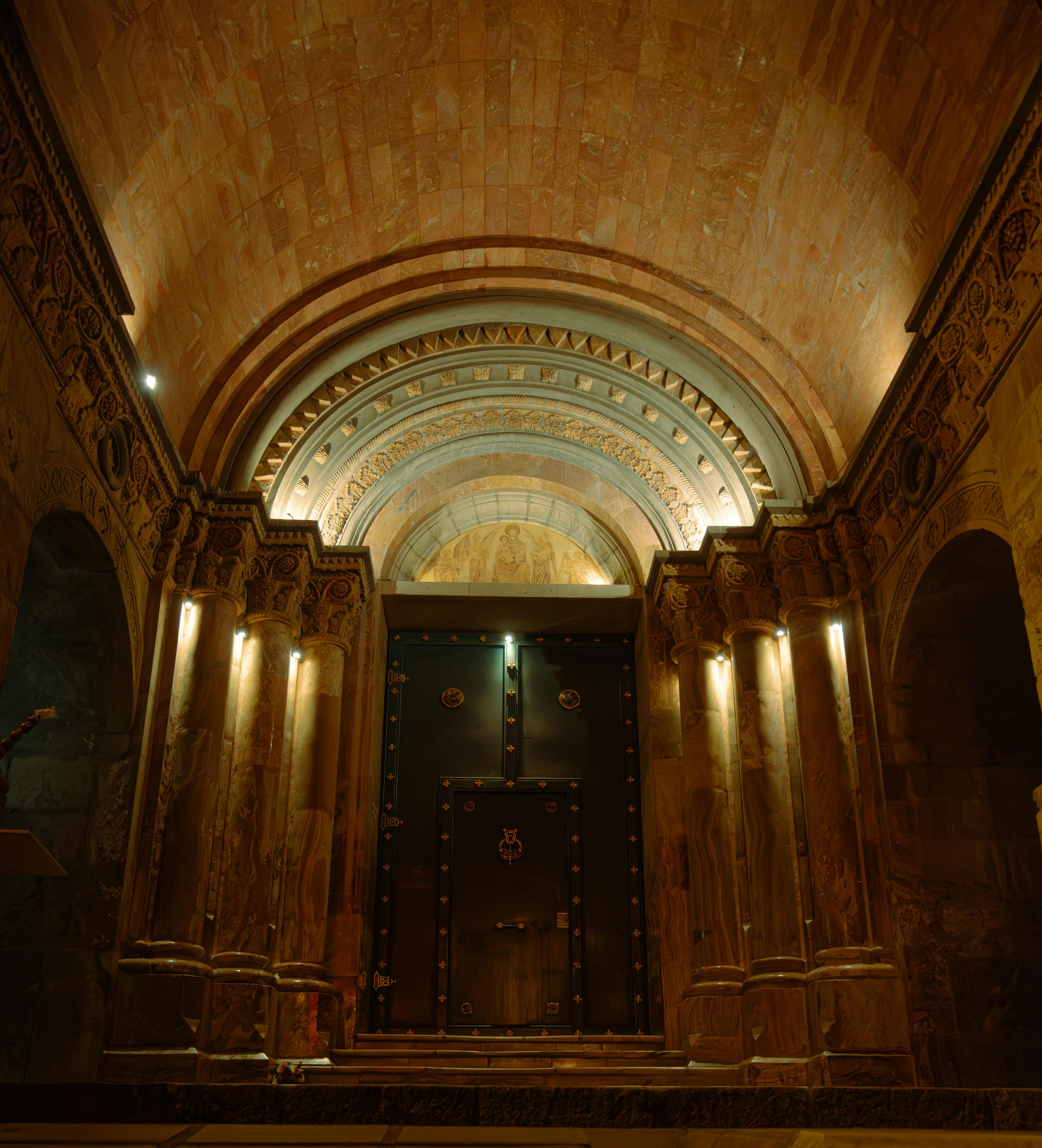 Free Magnificent architectural interior featuring a vaulted ceiling and ornate columns, illuminated warmly. Stock Photo