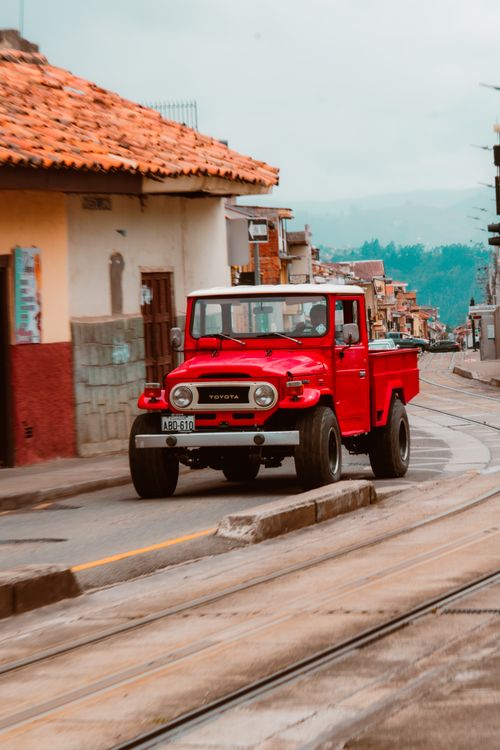 Free A red Toyota truck drives through the charming streets of Cuenca, Ecuador. Stock Photo