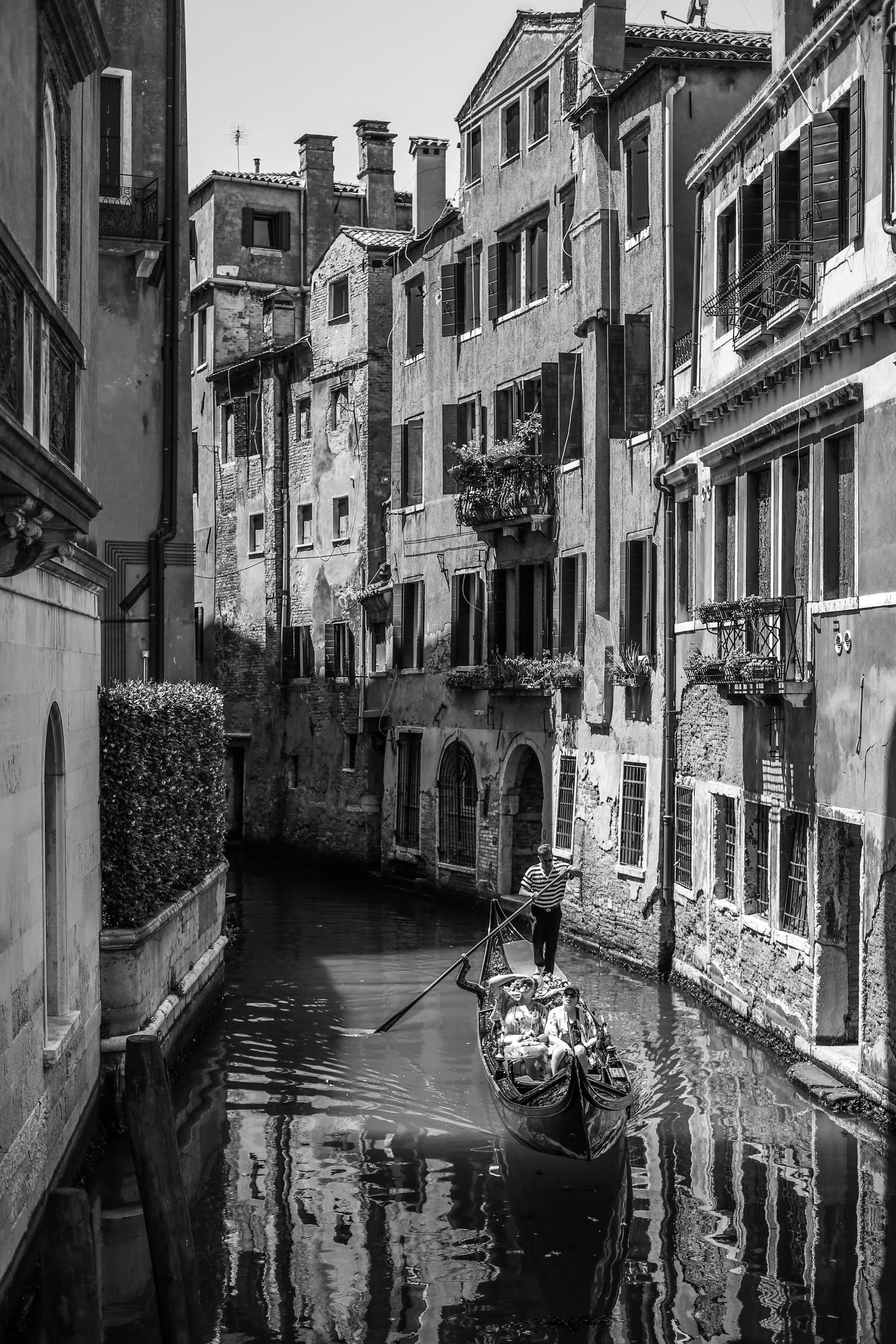 Classic Venetian scene with a gondola navigating a narrow canal in Veneto, Italy.