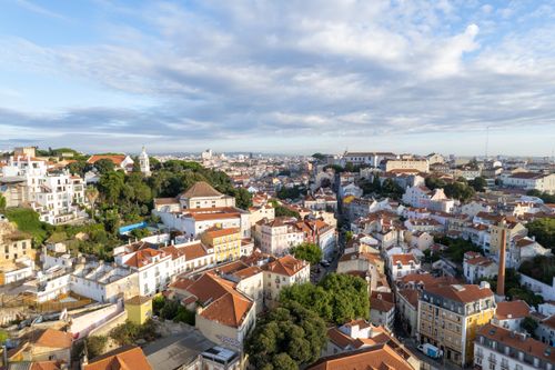 Free A breathtaking panoramic view of Lisbon's rooftops and cityscape under a bright blue sky. Stock Photo