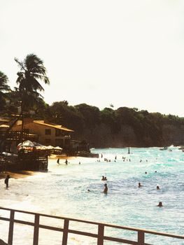 Sun-soaked beach scene at Pipa Beach, Brazil with visitors enjoying the sea and sun.
