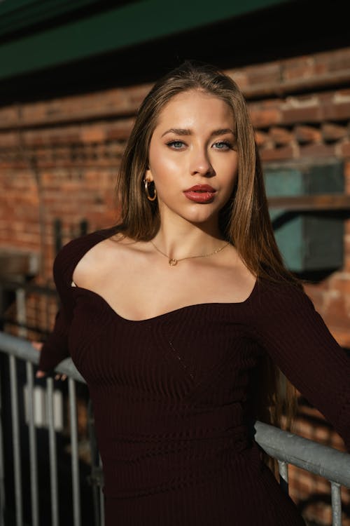 Model in Black Dress Posing by Fence