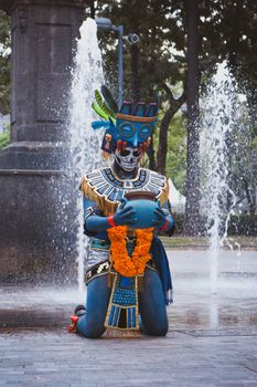 Vibrant Mayan priest performing near fountain with traditional costume. - Fotografer Sidoarjo