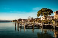 美丽的海滨小镇，湖水倒映着建筑物、树木和码头，天空清澈湛蓝