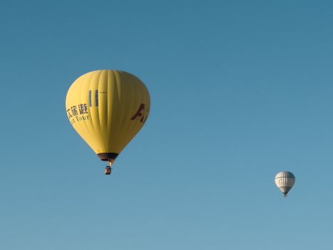 Vibrant hot air balloons gently floating in a clear blue sky, perfect for adventure enthusiasts.