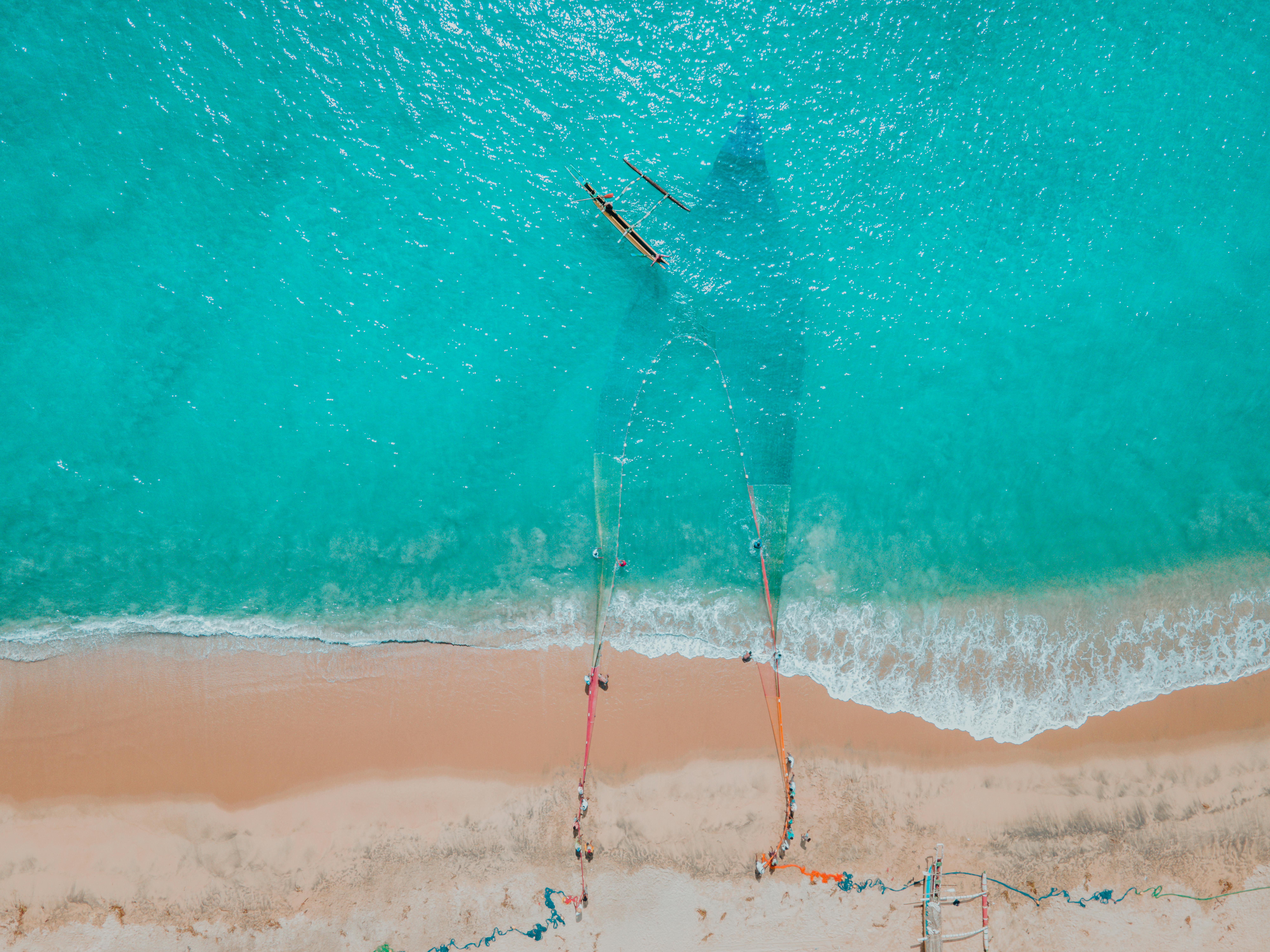 A breathtaking aerial shot of fishermen casting nets on Kalmunai Beach, Sri Lanka.