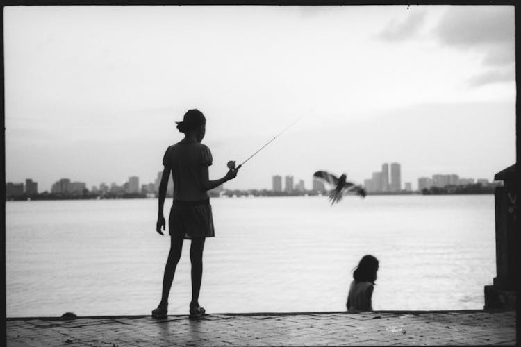 Silhouette Of Woman With A Fishing Rod In Black And White